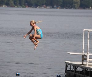 Girl jumping in lake